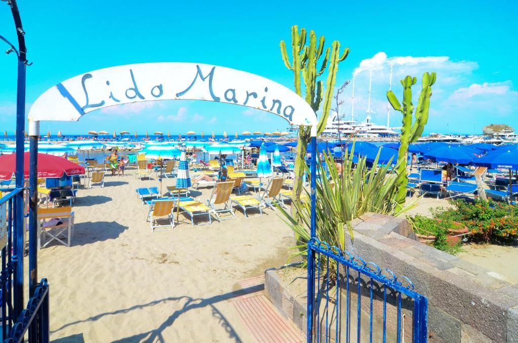 a beach with chairs and umbrellas and aoked marina at Hotel Terme Marina in Ischia