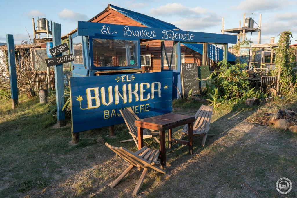 a blue food truck with a table and two chairs at Bunker Hostel in Cabo Polonio