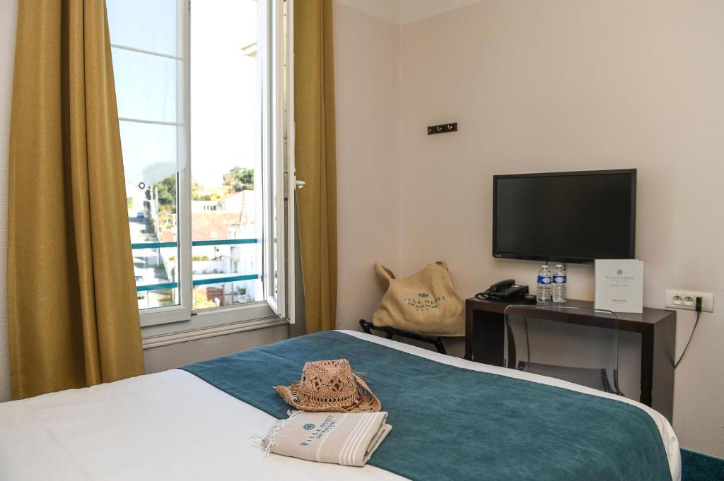 a hotel room with a bed and a television at The Originals Boutique La Villa Ouest &amp; Spa in Saint-Palais-sur-Mer