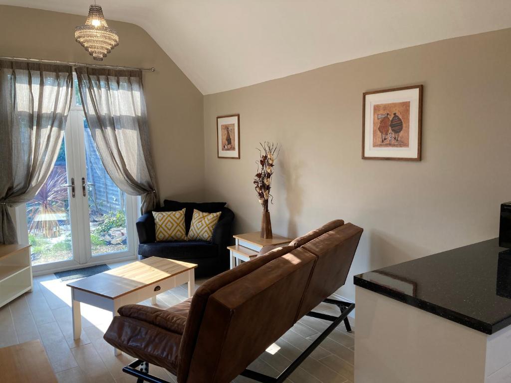 a living room with a couch and a table at Garfield Cottage in Kettering