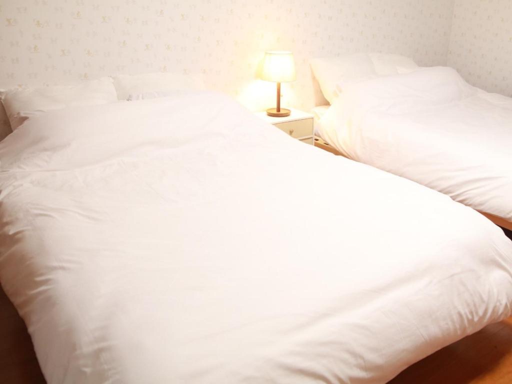 two white beds sitting next to each other in a bedroom at Chiba - House - Vacation STAY 41221v in Chiba