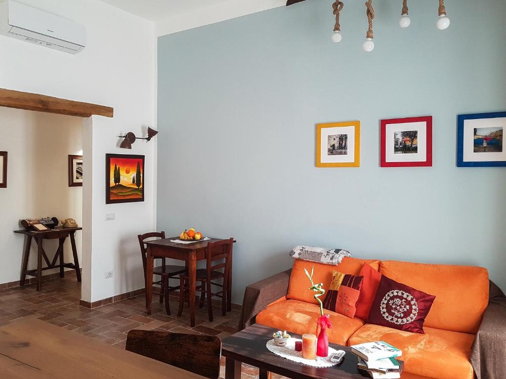 un soggiorno con divano arancione e tavolo di il Rifugio dell'Artista a Passignano sul Trasimeno