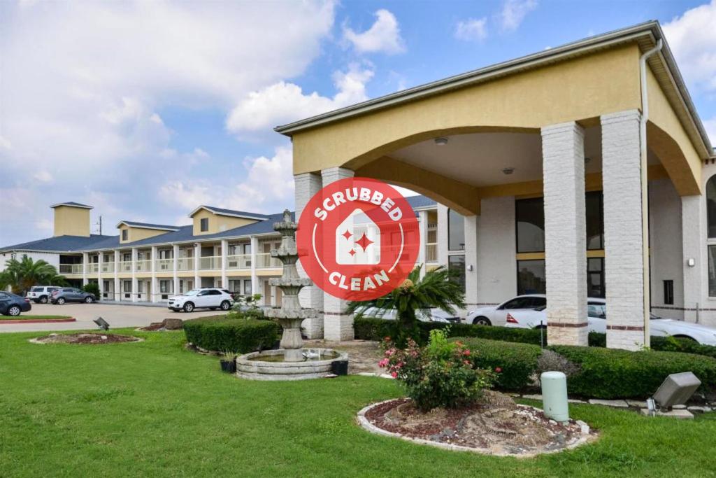 a hotel with a sign in front of a building at OYO Hotel Stafford TX I-69 North in Stafford