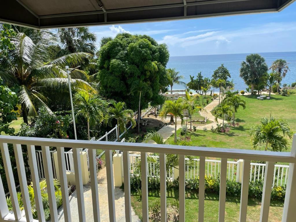 uma varanda com vista para o oceano e para as palmeiras em Westmore Beach Villas Limited em Whitehouse