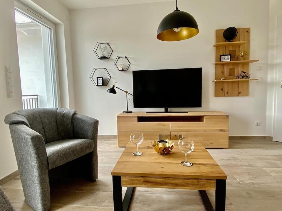 una sala de estar con una silla y una mesa con copas de vino en Ferienwohnung Tor zum Meer - Neubau mit Sauna, Fahrstuhl und Tiefgarage en Kühlungsborn