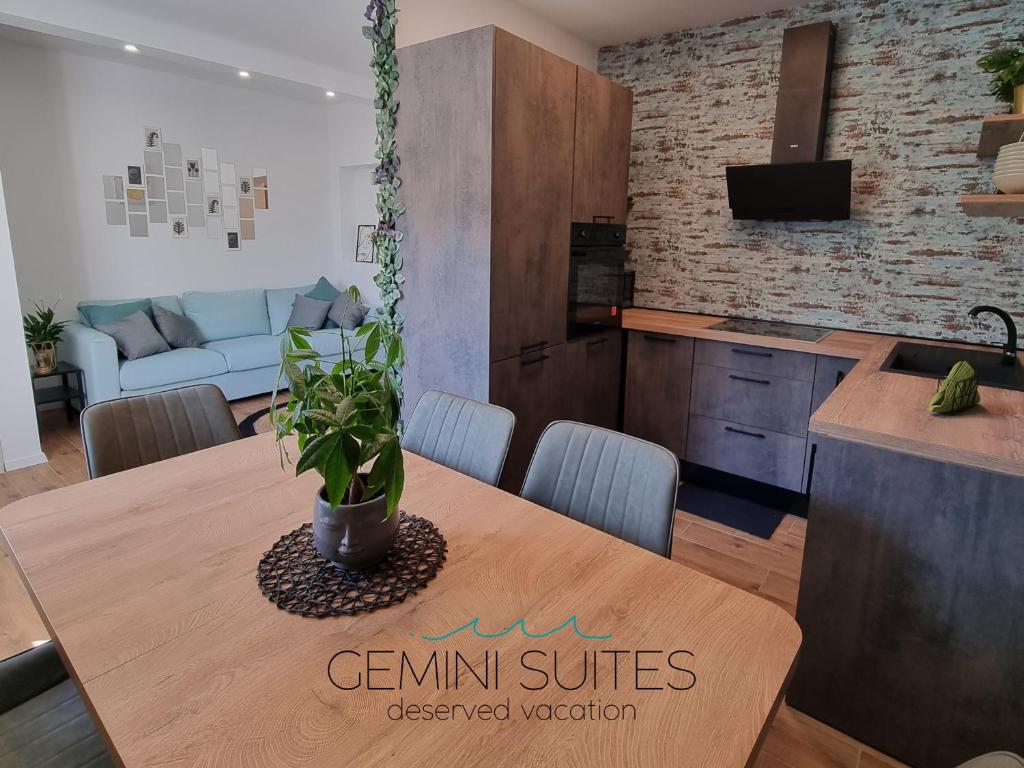 a kitchen and living room with a table and a couch at Gemini Suites in Kaštela