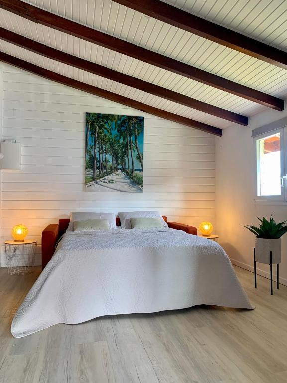 um quarto com uma grande cama branca em um quarto em SOMPTUEUX DUPLEX SUR LA ROUTE DES PLAGES em Sainte-Anne