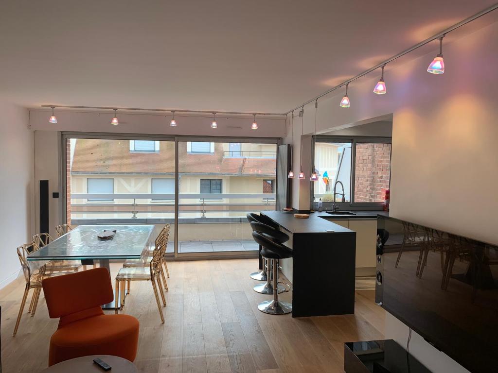 a kitchen and dining room with a table and chairs at Appartement design en plein centre du Touquet in Le Touquet-Paris-Plage