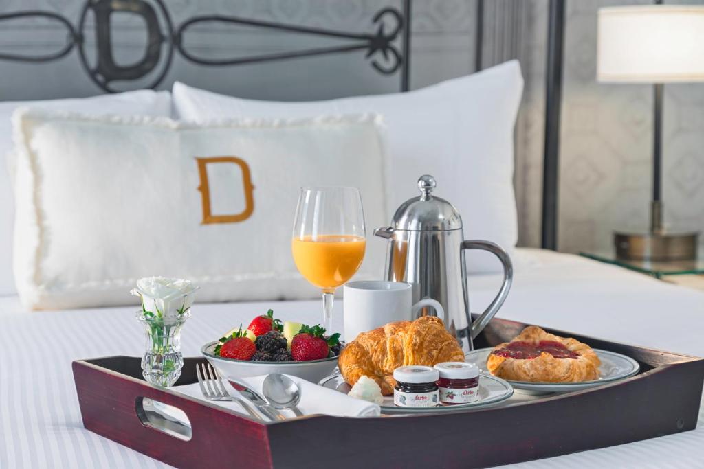 a tray of food and fruit on a bed at The Driskill, in The Unbound Collection by Hyatt in Austin