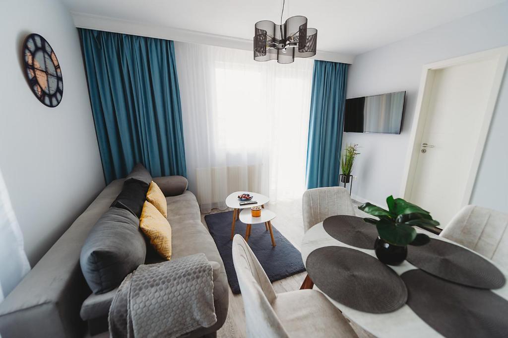 een woonkamer met een bank en een tafel bij Apartament Alex in Sibiu