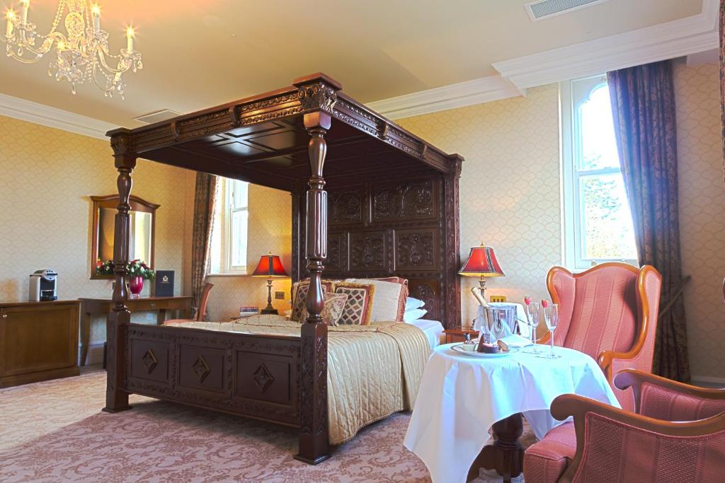 a bedroom with a bed and a dresser at Kilronan Castle Hotel & Spa in Ballyfarnon
