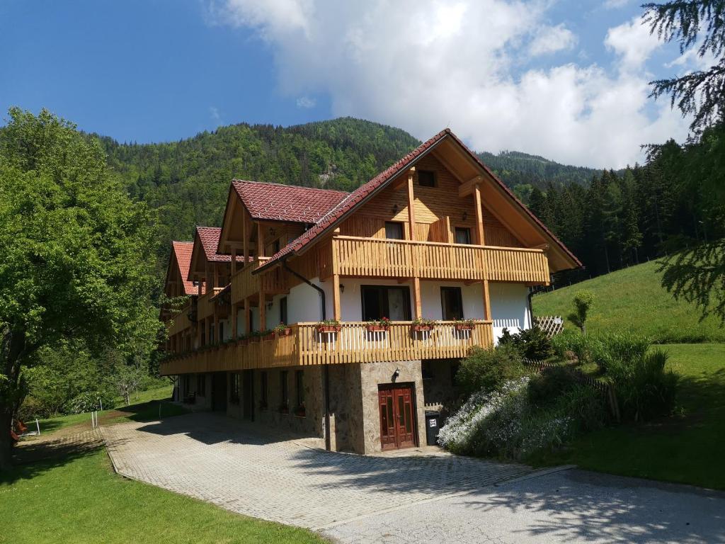 a large wooden house with a balcony on a mountain at Turistična Kmetija Zgornji Zavratnik in Luče