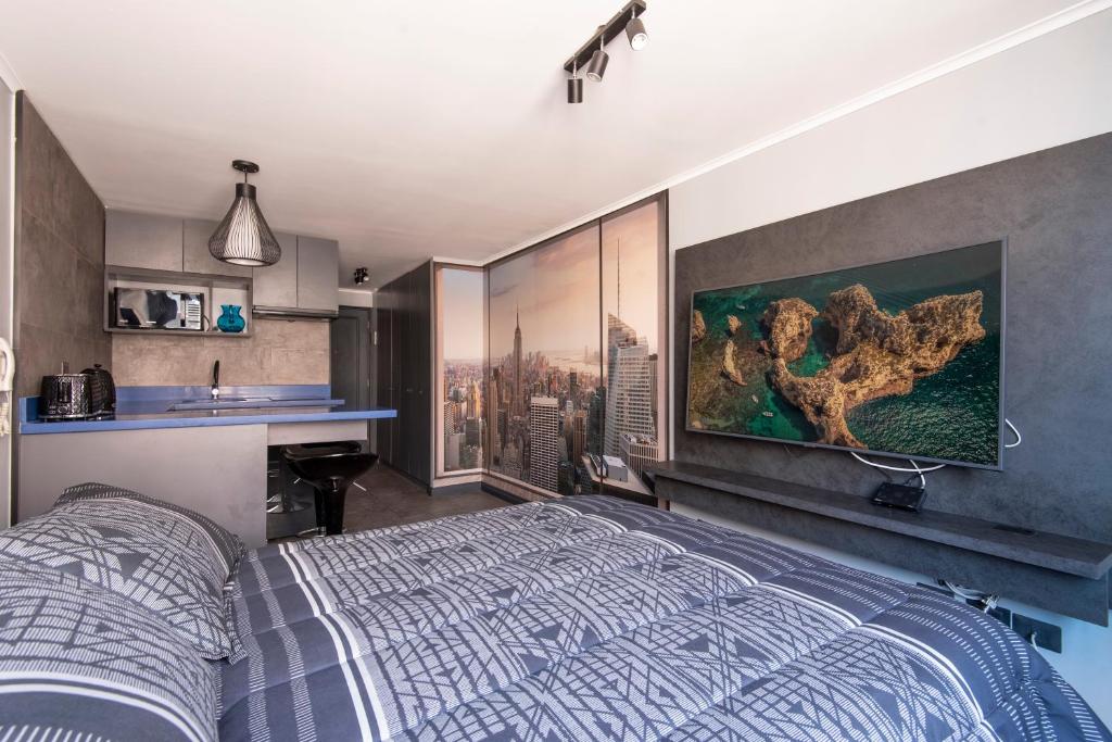 1 dormitorio con 1 cama y una pintura en la pared en Encomenderos Design Tech Comfort & Location, en Santiago