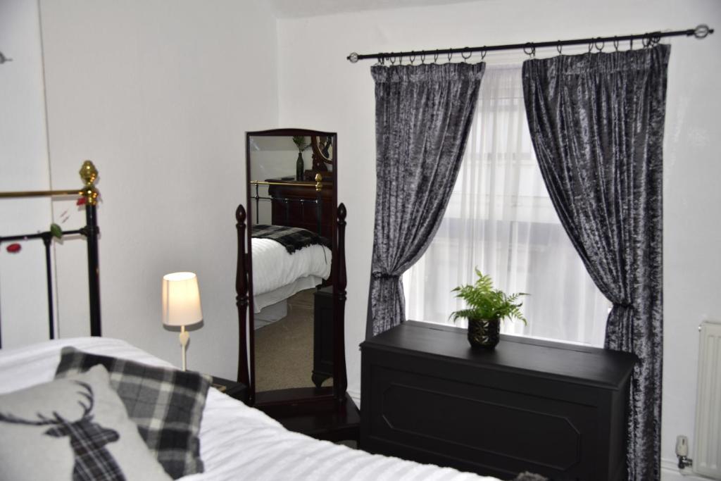 - une chambre avec un lit et un miroir dans l'établissement 6 Bryn Terrace, Conwy, à Conwy