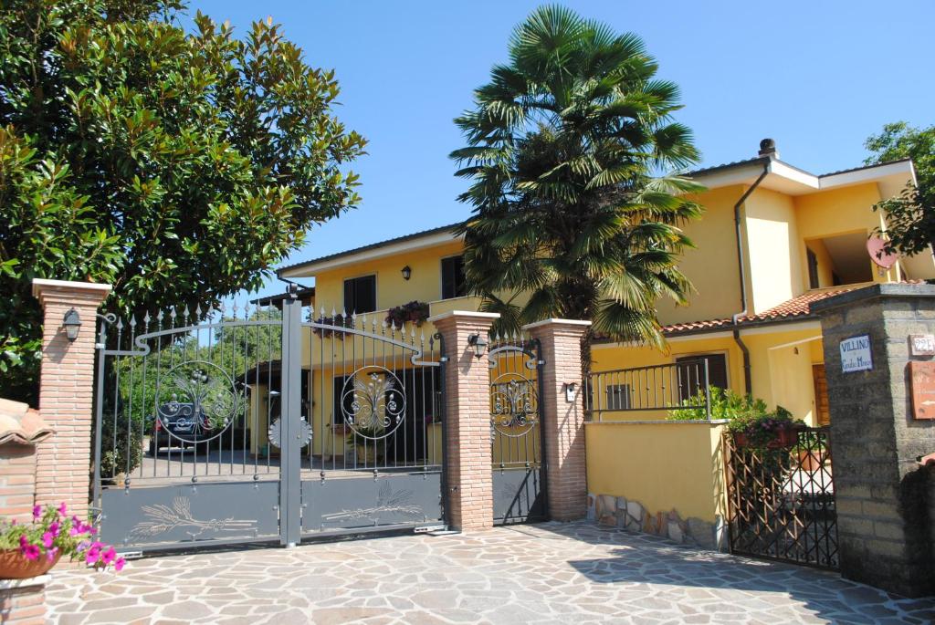una puerta frente a una casa con una palmera en B&B Al Castagneto, en Valmontone