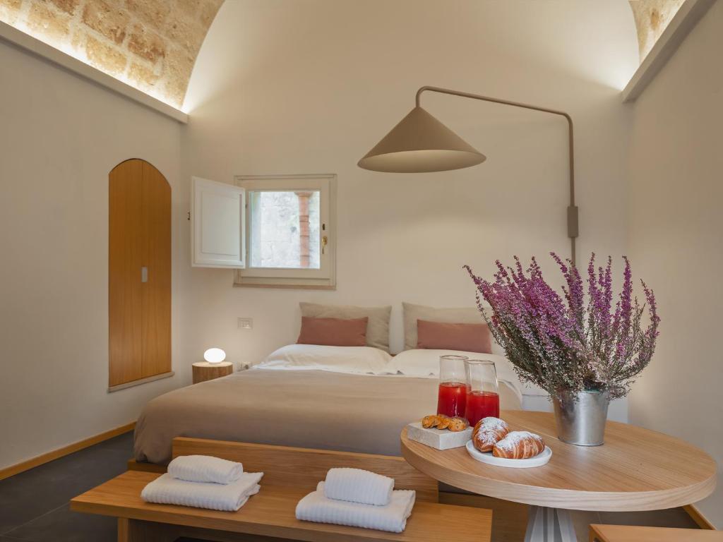 ein Schlafzimmer mit einem Bett und einem Tisch mit Essen darauf in der Unterkunft San Giovanni Vecchio - Residenza in Matera