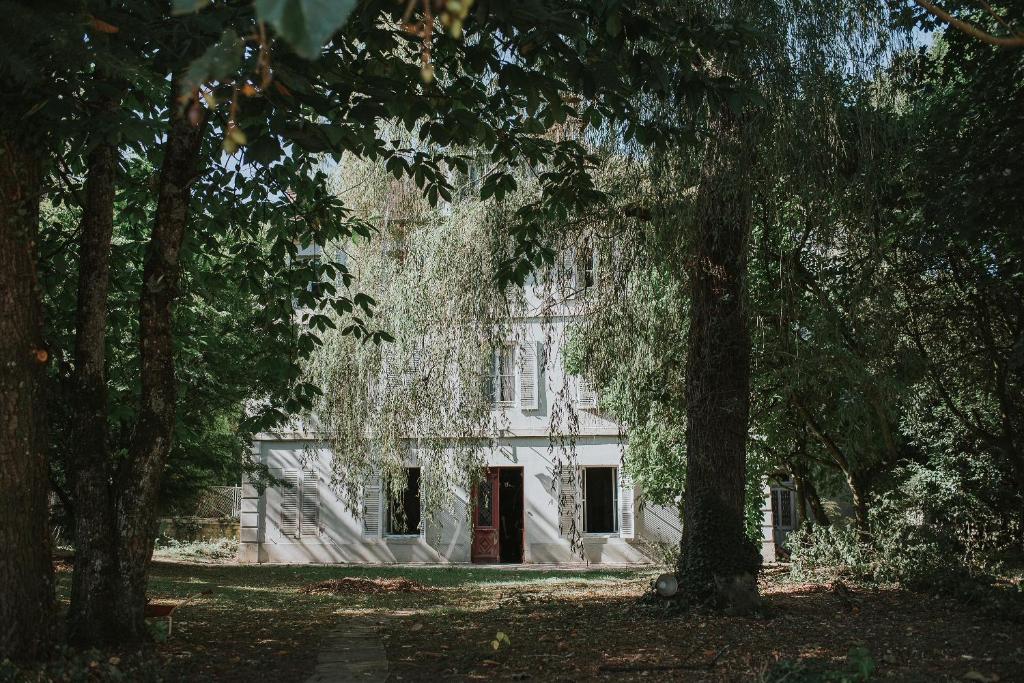 格赫的住宿－La Rose du Cèdre，前面有树木的白色房子