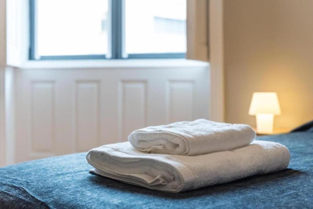 sterta ręczników na łóżku w obiekcie Serenata Boutique Rooms w Porto