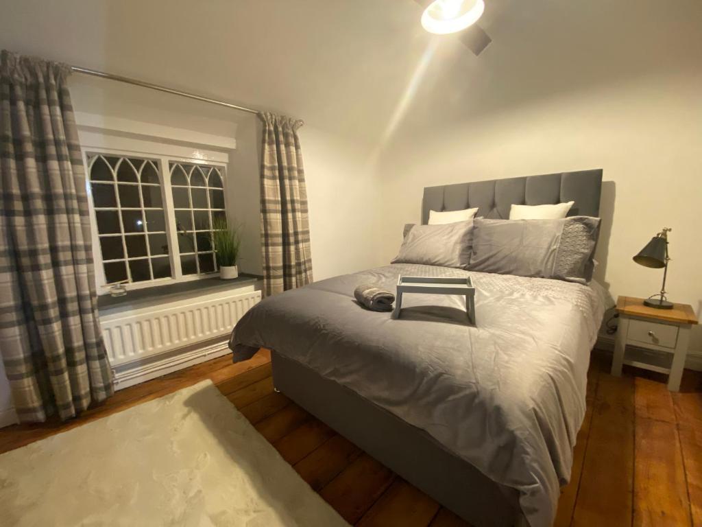 Un dormitorio con una cama grande y una ventana en Abbey Cottage en Llangollen