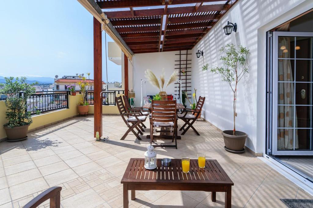 een patio met een tafel en stoelen op een balkon bij Central penthouse in quiet neighborhood near sandy beach in Chania