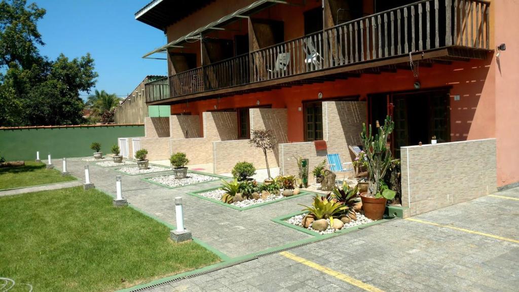 um edifício com um monte de plantas em frente dele em Massaguas beach em Caraguatatuba
