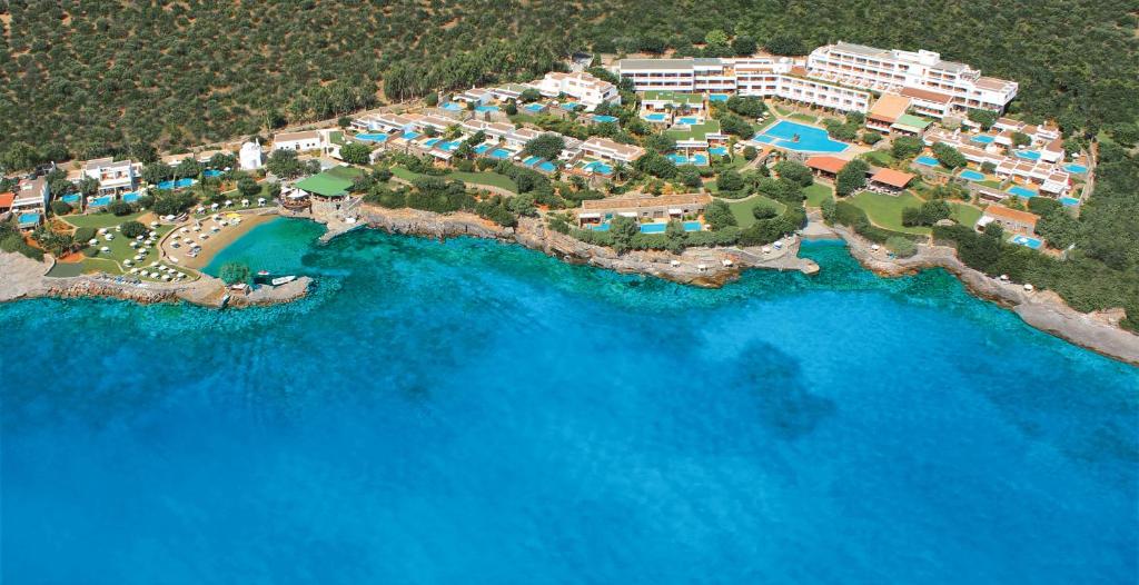 
a beach filled with lots of blue and white water at Elounda Mare Relais & Châteaux Hotel in Elounda
