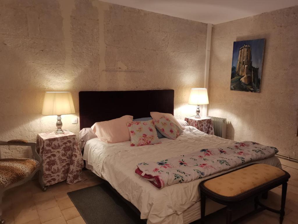 una camera con un letto con due tavoli e due lampade di La Chambre de la Mine a Villedieu-le-Château