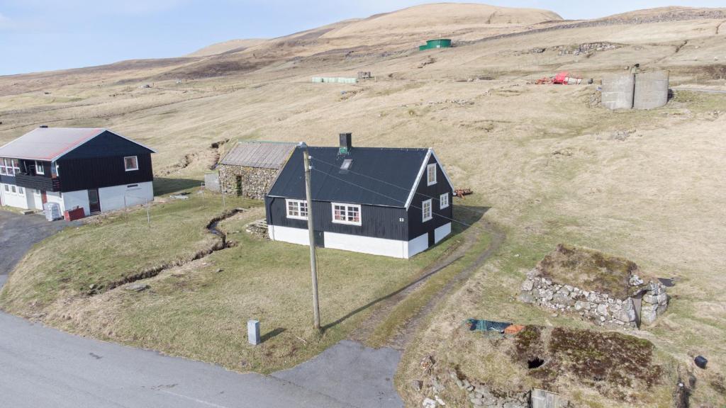 een luchtzicht op een huis op een heuvel bij The Real Faroese Experience in Skálavík