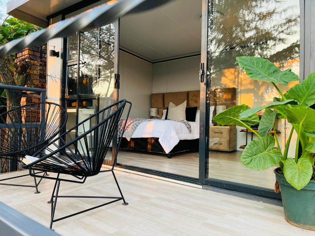 Zimmer mit einem Bett und einem Stuhl auf einem Balkon in der Unterkunft The Point of View Cabin in Johannesburg
