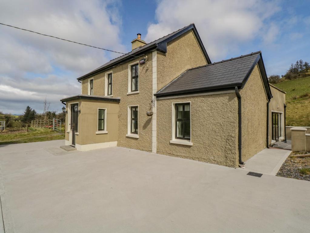 a large brick house with a large driveway at Hannon's Country Farmhouse in Ballymote