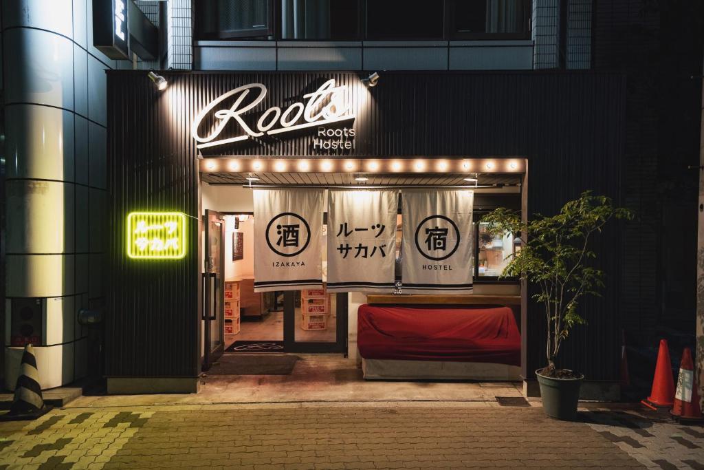 a neon sign on the side of a building at Roots Hostel in Osaka