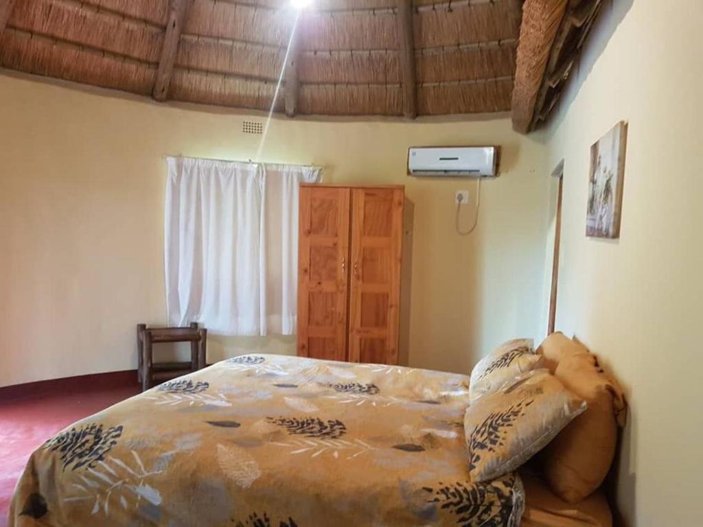 a bedroom with a bed in a room with a window at Lituba Lodge 
