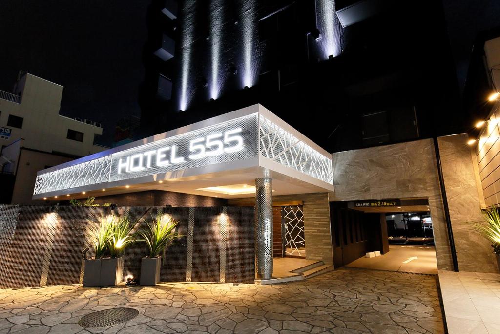 una señal de hotel en el lateral de un edificio en HOTEL555 沼津駅北, en Numazu