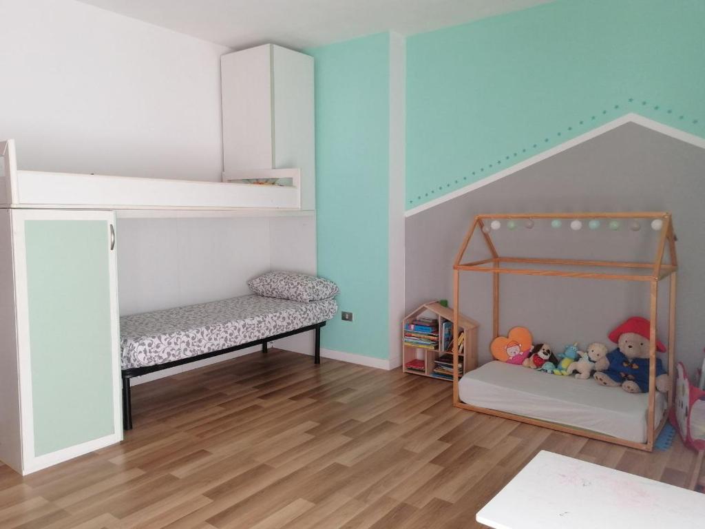 um quarto para crianças com um beliche e um berço em Ampio attico vista mare tra comfort e tranquillità em Silvi Marina