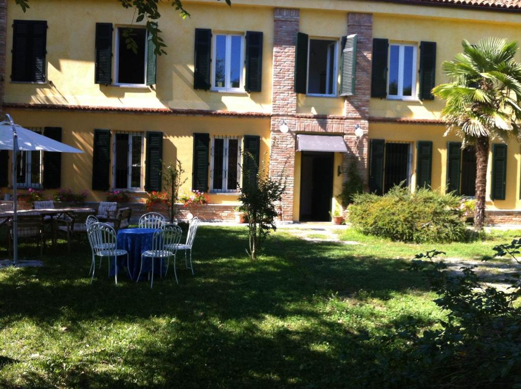 ein Haus mit einem Tisch und Stühlen im Hof in der Unterkunft Casale di Charme Bellaria in Rocca D'Arazzo