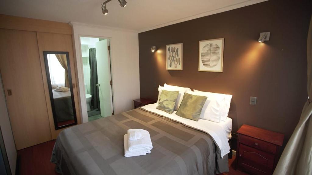 Habitación de hotel con cama y espejo en Espacio Norte Familiar - Cavancha, en Iquique