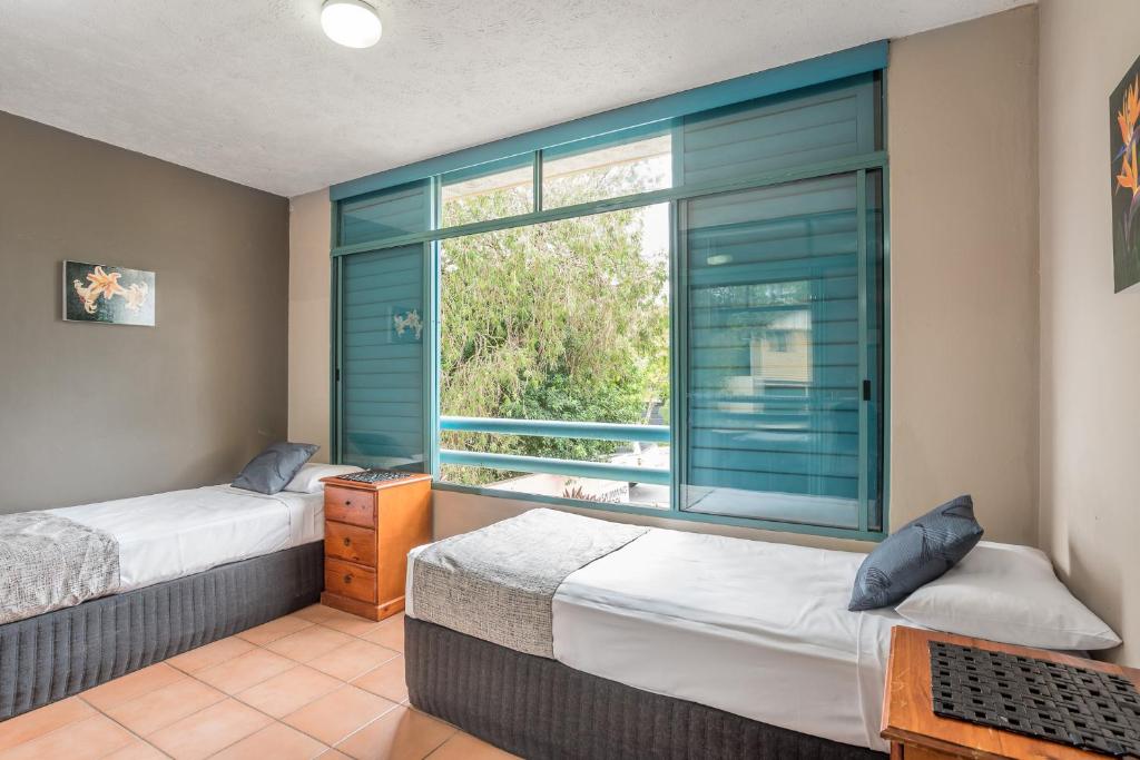 Un dormitorio con dos camas y una ventana. en Albion Manor, en Brisbane