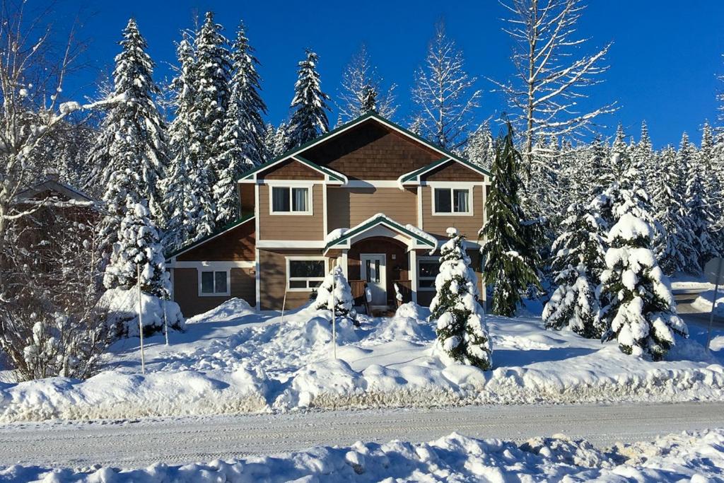 ein Haus im Schnee mit schneebedeckten Bäumen in der Unterkunft Snoqualmie Palace in Snoqualmie Pass