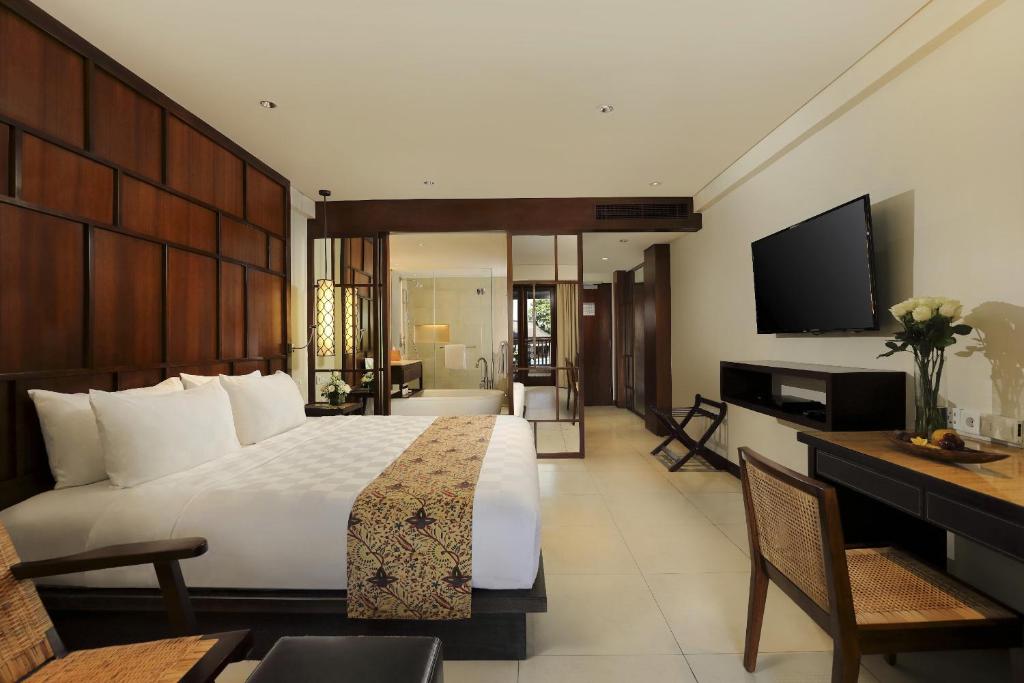 a hotel room with a bed and a television at Padma Resort Legian in Legian