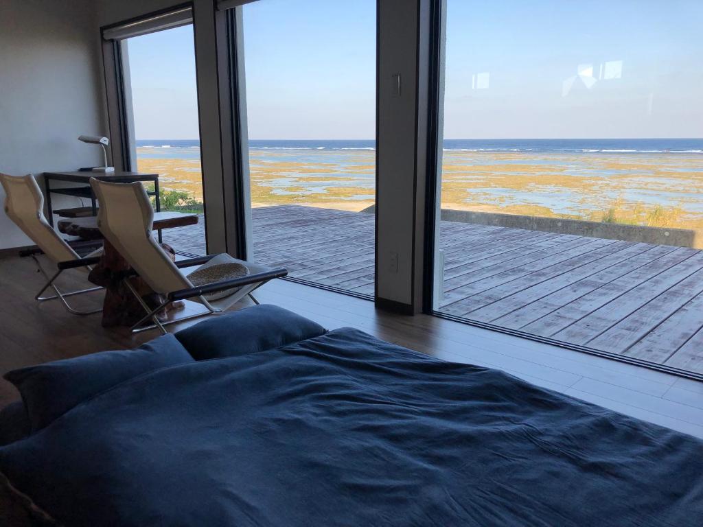 a living room with a view of the ocean at ゴールデンマイルヴィラ in Amami