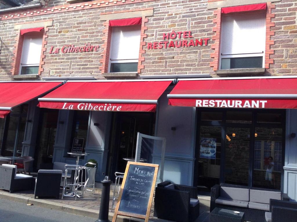 a restaurant with a red awning on a building at Hôtel La Gibecière in Lohéac