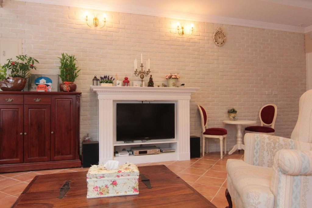 a living room with a television and a brick wall at Beautiful Life B&amp;B in Dongshan