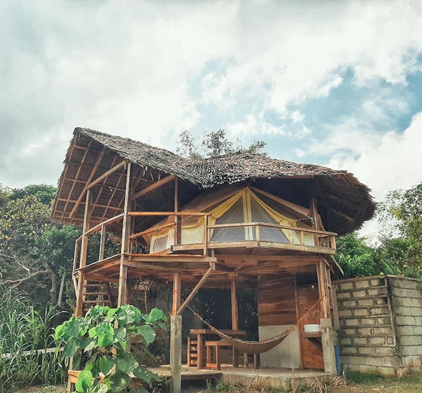 drewniany dom ze słomianym dachem w obiekcie Cabanas de Nacpan Camping Resort w mieście El Nido