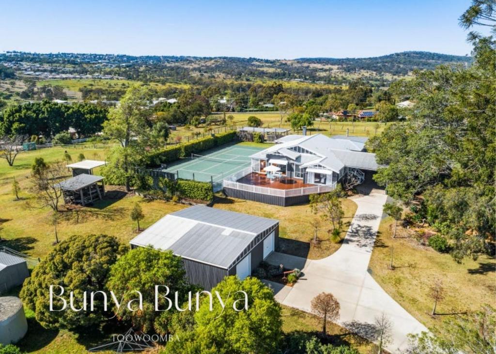 トゥーンバにあるBunya Bunya Luxury Estate Toowoomba set over 2 acres with Tennis Courtのテニスコート付きの家屋の空中ビュー