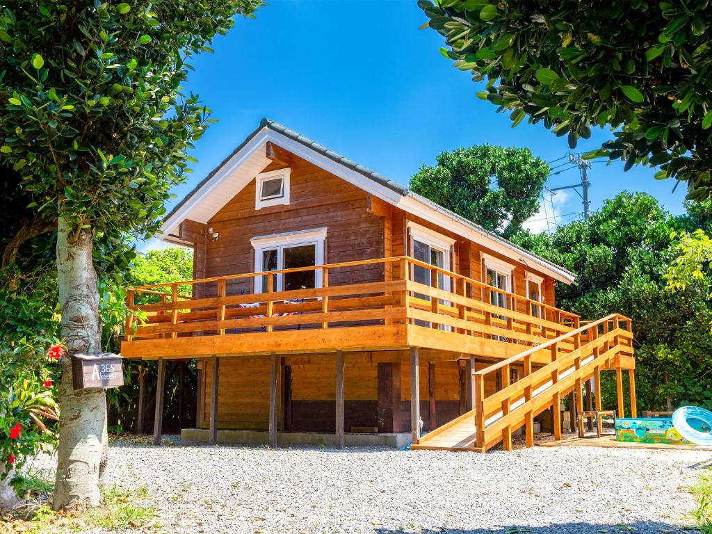 una grande casa in legno con un ampio ponte di 石垣島コテージAkeeesi365 a Isola di Ishigaki