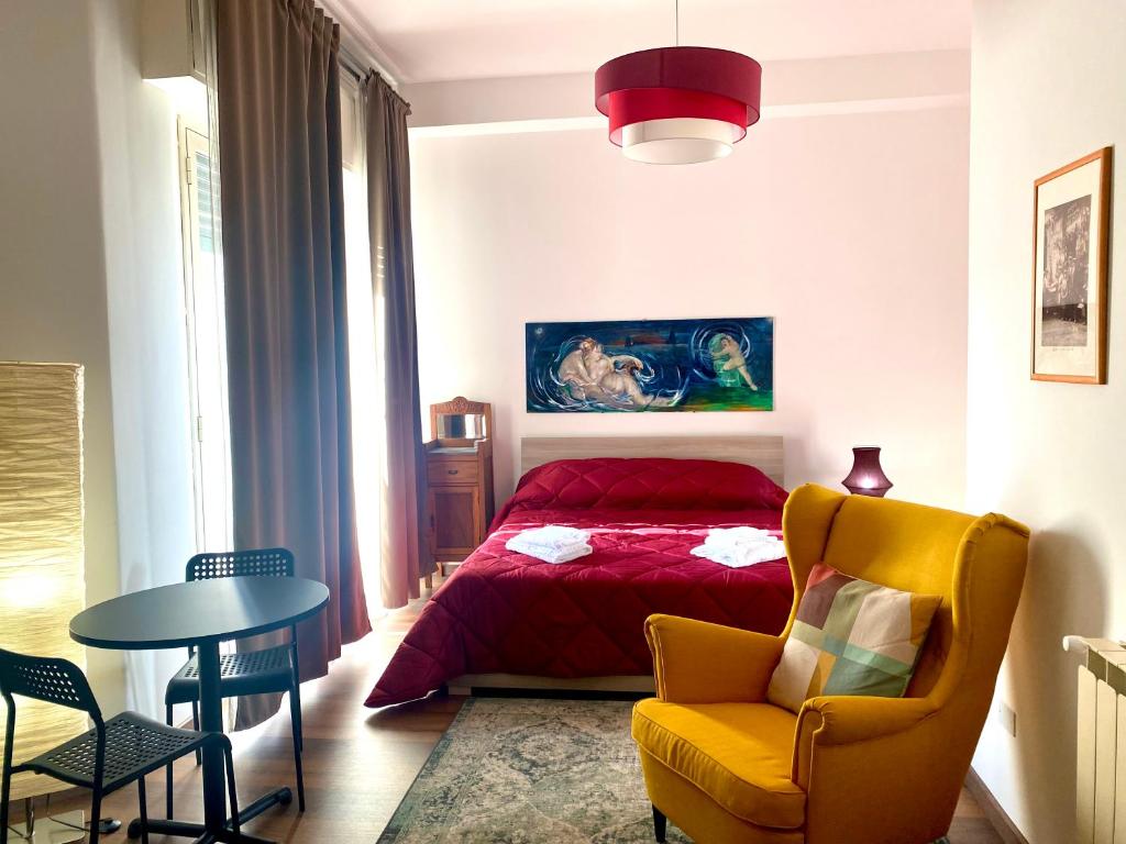 a bedroom with a bed and a chair and a table at B&B I miti dell Etna Catania Centro in Catania