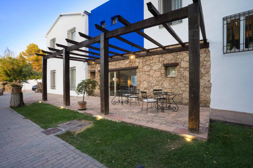 een patio met tafels en stoelen voor een gebouw bij Las Aguas del Arbuniel con Pista de Pádel in Arbuniel