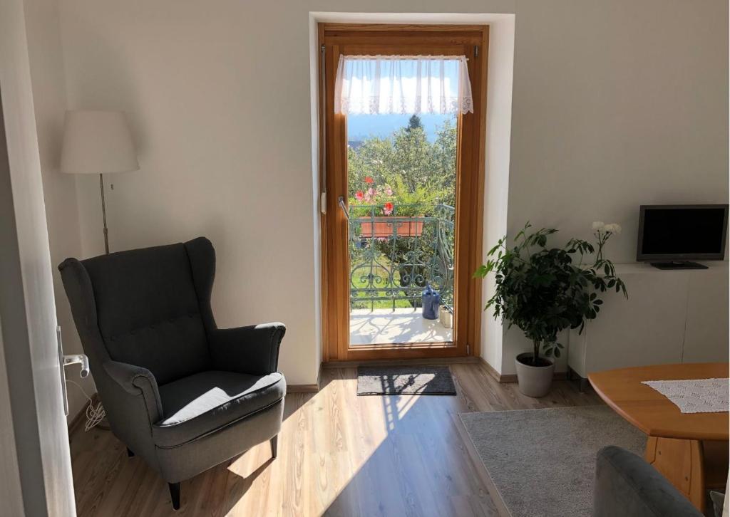 a living room with a chair and a window at Ferienwohnung Haus Sutter in Schopfheim