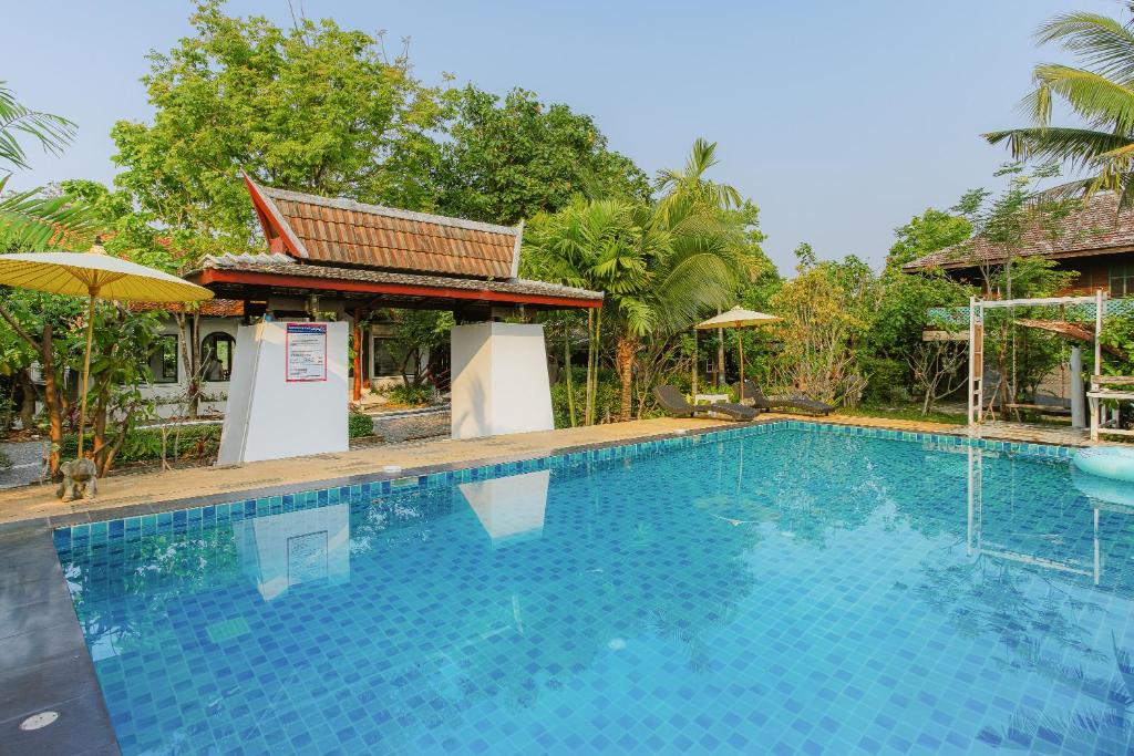 une grande piscine en face d'une maison dans l'établissement Chiang Mai Las Orquideas Resort, à Chiang Mai