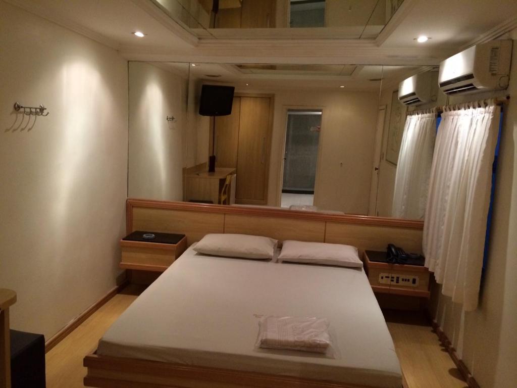 um quarto com uma cama e um espelho grande em Hotel Encontros (Adult Only) no Rio de Janeiro